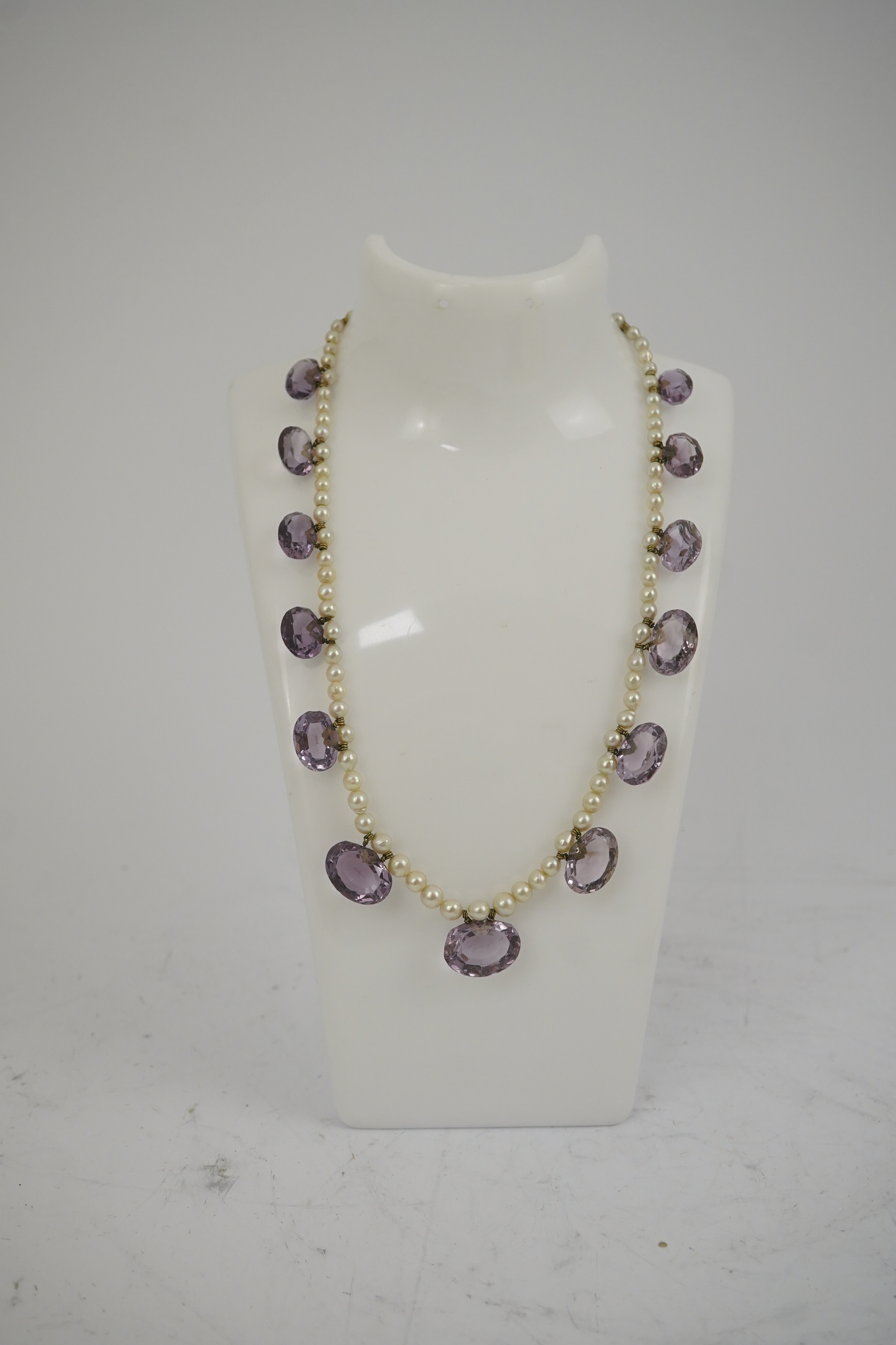 A 19th century pearl and graduated fifteen stone oval cut amethyst set drop necklace, with a gold barrel shaped clasp